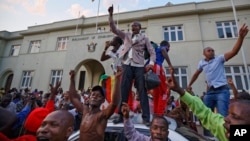 Zimbabweans celebrate outside the parliament building immediately after hearing the news that President Robert Mugabe had resigned, in downtown Harare, Zimbabwe, Nov. 21, 2017. 