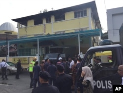 Police prepare to bring victims out of an Islamic religious school after a fire on the outskirts of Kuala Lumpur, Malaysia, Sept. 14, 2017. A fire department official in Malaysia said the fire at the school killed people, mostly teenagers.