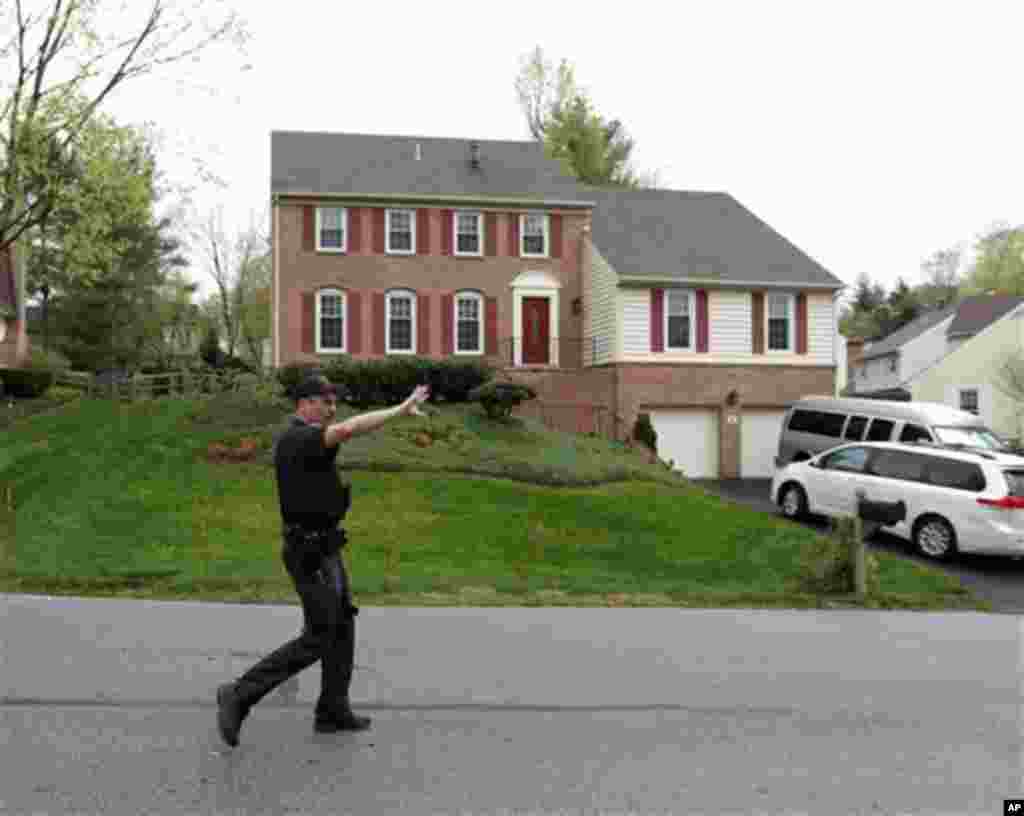 A Montgomery County, Md. police officer pushes the media back from in front of the house of the uncle of the Boston Marathon bombing suspects, Friday, April 19, 2013, in Montgomery Village in Md. The uncle, Ruslan Tsarni of Montgomery Village, Md., told T