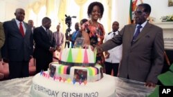 Zimbabwean President Robert Mugabe (R) and his wife Grace cut his birthday cake in Harare, Feb. 22, 2016. Staff in the President's office organized a surprise birthday celebration ahead of Saturday's birthday bash.