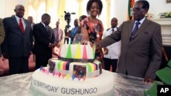 Zimbabwean President Robert Mugabe (R) and his wife Grace cut his birthday cake in Harare, Feb. 22, 2016. Staff in the President's office organized a surprise birthday celebration ahead of Saturday's birthday bash.