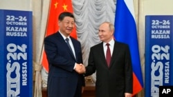 Tổng thống Nga Vladimir Putin, phải, bắt tay Chủ tịch Trung Quốc Tập Cận Bình bên lề hội nghị thượng đỉnh khối BRICS tại Kazan Kremlin ở Kazan, Nga, ngày 22/10/2024. Điện Kremlin nói việc lựa chọn ai sẽ trở thành tổng thống Hoa Kỳ là do người dân Hoa Kỳ quyết định.