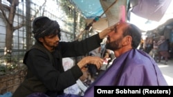 Seorang pria Afghanistan mencukur jenggotnya di sebuah pangkas rambut jalanan di Kabul, Afghanistan 11 Oktober 2017. (Foto: REUTERS/Omar Sobhani)