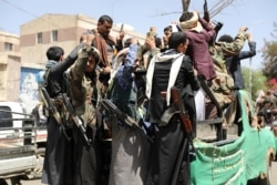 FILE - Armed Houthi followers ride on the back of a truck outside a hospital in Sanaa, Yemen, April 8, 2020.