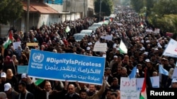 Palestinian employees of the United Nations Relief and Works Agency (UNRWA) hold signs during a protest against a U.S. decision to cut aid, in Gaza City, Jan. 29, 2018. 