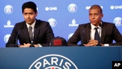 FILE - Chairman of Paris Saint-Germain Nasser al-Khelaifi and French soccer player Kylian Mbappe, right, attend a press conference in Paris, Sept. 6, 2017.