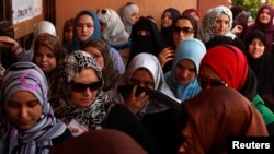 FILE - Women wait to vote at a polling station during national assembly elections in Tripoli, July 7, 2012. 