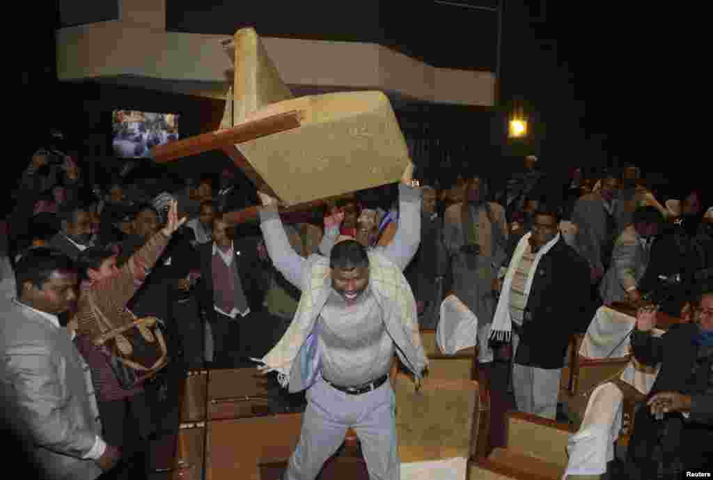 Seorang anggota DPR partai oposisi yang marah melempar kursinya dalam perdebatan di parlemen Nepal di Kathmandu.