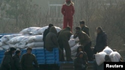 지난 2008년 12월 북한 신의주 주민들이 미국에서 지원 받은 식량을 트럭에서 내리고 있다. 자루에 'USAID(미국제개발처)' '미국에서 보내온 선물' 이란 문구가 씌여있다.