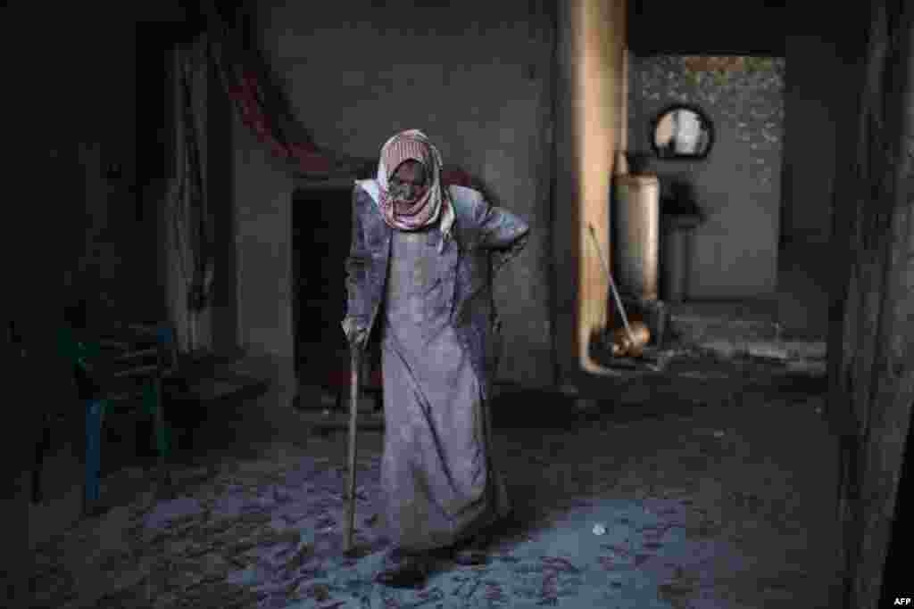 Abu Mohammed, covered with dust from explosions, walks in his home following reported air strikes by regime forces on the town of al-Nashabiyah in the eastern Ghouta region, a rebel stronghold east of the capital Damascus, Syria.