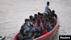 Migrantes hondureños tratan de cruzar el río Usumancinta desde Guatemala a México, para proseguir su marcha hacia Estados Unidos, el 6 de marzo de 2021.