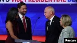 Democratic vice presidential nominee Minnesota Governor Tim Walz and his wife, Gwen, and Republican vice presidential nominee U.S. Senator JD Vance and his wife, Usha, speak at the end of the Vice Presidential debate hosted by CBS in New York, October 1, 2024.