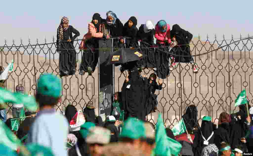 Houthi supporters hang off an iron fence during a rally marking the birth anniversary of Islam&#39;s Prophet Mohammad, in Sana&#39;a, Yemen.
