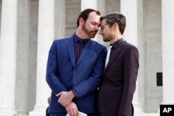 FILE - Charlie Craig, left, and David Mullins leave the Supreme Court, which is hearing the case, the Masterpiece Cakeshop v. Colorado Civil Rights Commission, Dec. 5, 2017, in Washington. Baker Jack Phillips refused to bake a cake for their wedding, on religious grounds.
