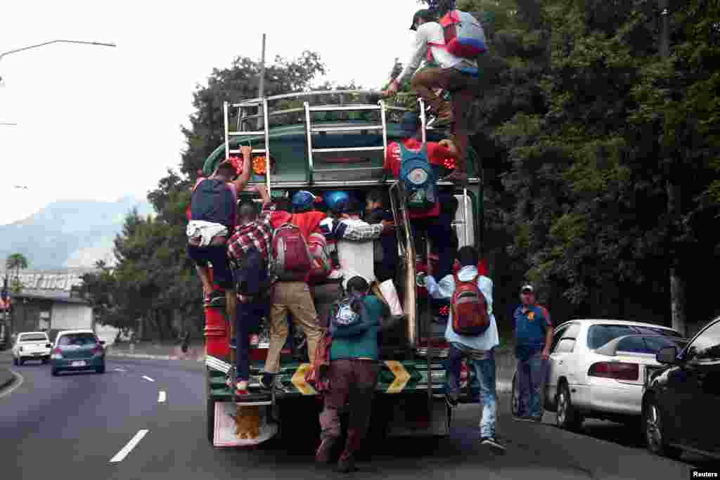 Honduran migrants, part of a caravan trying to reach the U.S., climb on a bus during a new leg of their journey, in Guatemala City, Guatemala.