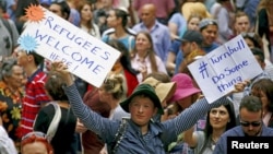 Demonstrators hold placards during a rally in support of refugees that was part of a national campaign in central Sydney, Australia, Oct. 11, 2015.