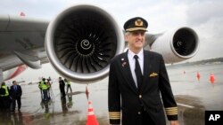 Richard de Crespigny, the pilot who was responsible for safely landing a damaged Qantas Airbus plane in 2010, stands in front of the engine (AP Photo/Wong Maye-E)