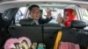 Wali Kota Bandung Ridwan Kamil, calon Gubernur Jawa Barat, dan istrinya, Atalia Kamil, melambaikan tangan ke para wartawan dari dalam mobil di Bandung, 20 Januari 2018. (Foto: Antara via Reuters)