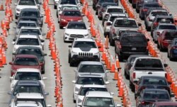 Lines of cars wait at a coronavirus testing site outside of Hard Rock Stadium, in Miami Gardens, Fla., June 26, 2020.
