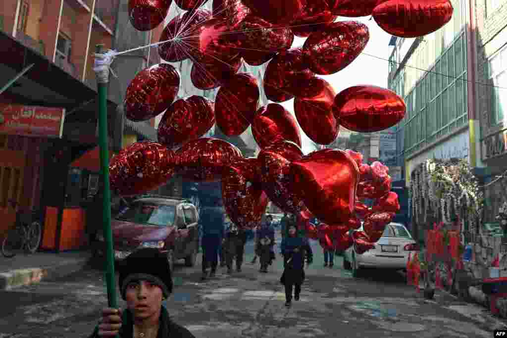 A child carries balloons to sell on Valentine&#39;s Day in Kabul, Afghanistan.