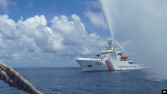 In this Sept. 23, 2015, file photo, Chinese Coast Guard members approach Filipino fishermen off Scarborough Shoal in the South China Sea. (AP Photo/Renato Etac)
