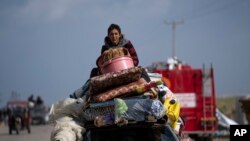 FILE - Palestinians arrive in the southern Gaza town of Rafah after fleeing an Israeli ground and air offensive in the nearby city of Khan Younis on January 24, 2024