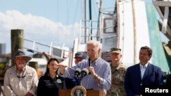 El presidente Joe Biden habla sobre la destrucción causada por el huracán Ian durante su visita a Fisherman's Wharf acompañado por la primera dama, Jill Biden, y el gobernador de Florida, Ron DeSantis (der), en Fort Myers Beach, Florida , EEUU, el 5 de octubre de 2022.