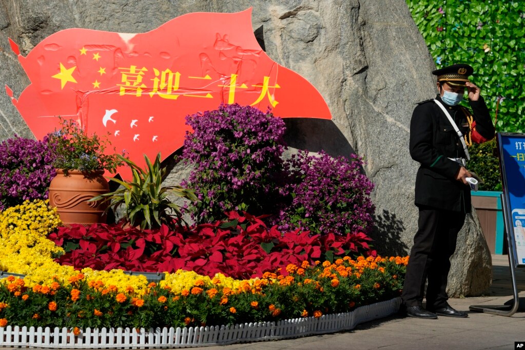 一名保安站在北京街头一处庆祝中共二十大的花坛旁。（2022年10月9日）(photo:VOA)