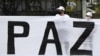 ARCHIVO - Excombatientes de las FARC y activistas sociales participan en una marcha para exigir al gobierno que garantice su derecho a la vida y el cumplimiento del acuerdo de paz de 2016, en Bogotá, Colombia, en noviembre de 2020.