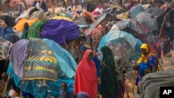 People walk through a displacement camp on the outskirts of Dollow, Somalia, Sept. 19, 2022. Severe drought and fallout from the war in Ukraine are being blamed as millions of people in the Horn of Africa region go hungry. 