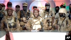 In this image from video broadcast by RTB state television, coup spokesman Capt. Kiswendsida Farouk Azaria Sorgho reads a statement in Ougadougou, Burkina Faso, Sept. 30, 2022. Members of Burkina Faso's army seized control of state television late Friday,