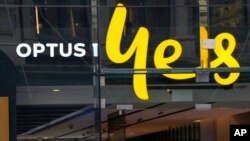 FILE - An Optus phone sign hangs above its store in Sydney, Oct. 7, 2021.