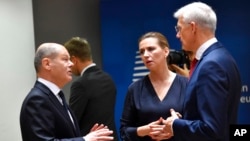 Germany's Chancellor Olaf Scholz, left, speaks with Latvia's Prime Minister Krisjanis Karins, right, and Denmark's Prime Minister Mette Frederiksen at an EU summit in Brussels, Oct. 21, 2022.