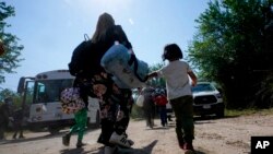 FILE - A migrant family from Venezuela walks to a Border Patrol transport vehicle after they and other migrants crossed the US-Mexico border and turned themselves in June 16, 2021, in Del Rio, Texas. 