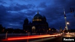FILE - The Television Tower glows at dusk next to the Protestant Berlin Cathedral with a reduced lighting to save energy due to Russia's invasion of Ukraine, in Berlin, Germany, Aug. 5, 2022.