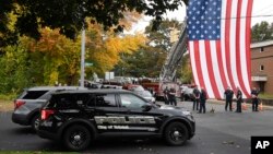 FILE - Police officers from Bristol, Connecticut, gather with officers from other towns at the scene where two police officers killed, in Bristol, Oct. 13, 2022.