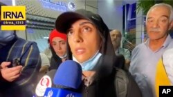 In this image taken from video by Iran's state-run IRNA news agency, Iranian competitive climber Elnaz Rekabi speaks to journalists in Imam Khomeini International Airport in Tehran, Iran, Oct. 19, 2022.