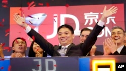 FILE - Liu Qiangdong, also known as Richard Liu, CEO of JD.com, raises his arms to celebrate the IPO for his company at the Nasdaq MarketSite, in New York on May 22, 2014.