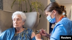 FILE - A nurse administers a COVID-19 vaccine booster to a woman at Victoria Manor Care home, in Edinburgh, Scotland, Britain, on Sept. 5, 2022.