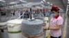 FILE - A worker watches as a machine processes cotton yarn at a Huafu Fashion plant, as seen during a government organized trip for foreign journalists, in Aksu in western China's Xinjiang Uyghur Autonomous Region, April 20, 2021.