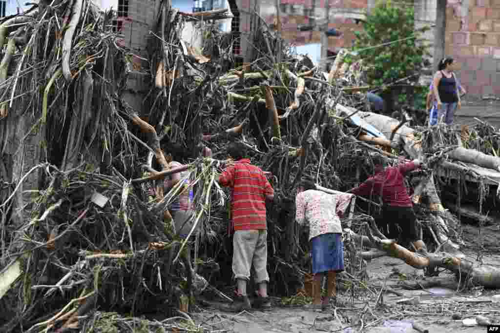 Residents search for their missing relatives in the rubble of a house destroyed by a landslide during heavy rains in Las Tejerias, Aragua state, Venezuela, Oct. 9, 2022.