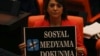FILE - A lawmaker from the main opposition Republican People's Party holds up a placard that reads "Don't touch my social media" in protest at the parliament, in Ankara, Turkey, Oct. 11, 2022.