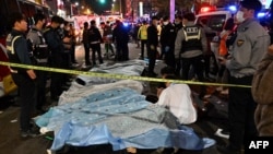 The bodies of victims killed in a Halloween crush are covered with sheets in the neighborhood of Itaewon in Seoul Oct. 30, 2022.