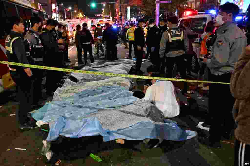 The bodies of victims killed in a Halloween crush are covered with sheets in the neighborhood of Itaewon in Seoul Oct. 30, 2022.