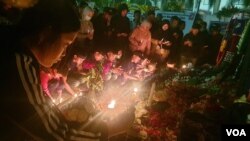 Suporter Arema FC menyalakan lilin, menabur bunga, dan memanjatkan doa bagi korban tragedi di Stadion Kanjuruhan (foto Petrus Riski-VOA)