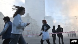 Local residents walk past police officers after a drone attack in Kyiv on Oct. 17, 2022, amid the Russian invasion of Ukraine.