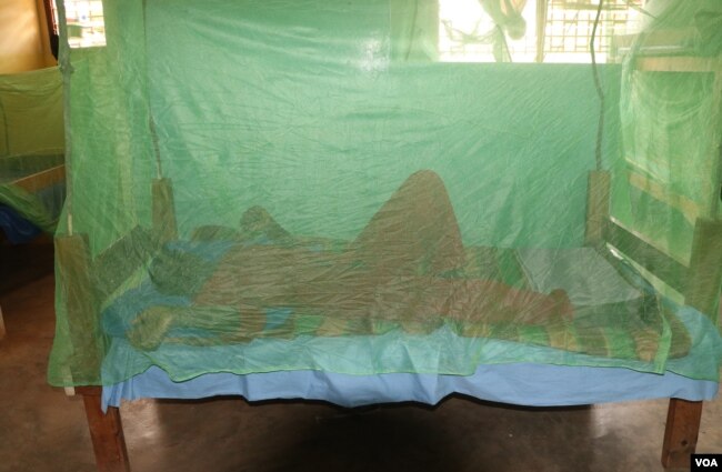 A person sleeps under a mosquito net in Balaka district, Malawi, Sept. 28, 2022, as people in the country are encouraged to do to help prevent malaria. (Lameck Masina/VOA)
