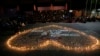 Supporters of soccer club Arema FC pray for the victims of Saturday's soccer match stampede outside the Kanjuruhan Stadium in Malang, Indonesia, Monday, Oct. 3, 2022.