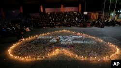 Supporters of soccer club Arema FC pray for the victims of Saturday's soccer match stampede outside the Kanjuruhan Stadium in Malang, Indonesia, Monday, Oct. 3, 2022.