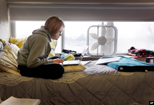 FILE - In this Dec. 9, 2014 file photo, Adrian College student Abby Slusher studies in her dorm in Adrian, Michigan. (AP Photo/Carlos Osorio/File photo)